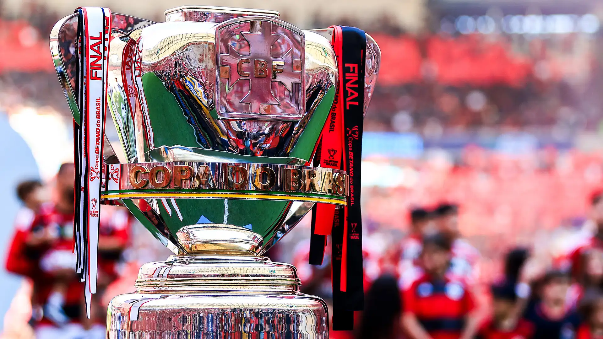 Taça da Copa do Brasil. No fundo, jogadores do Flamengo comemoram