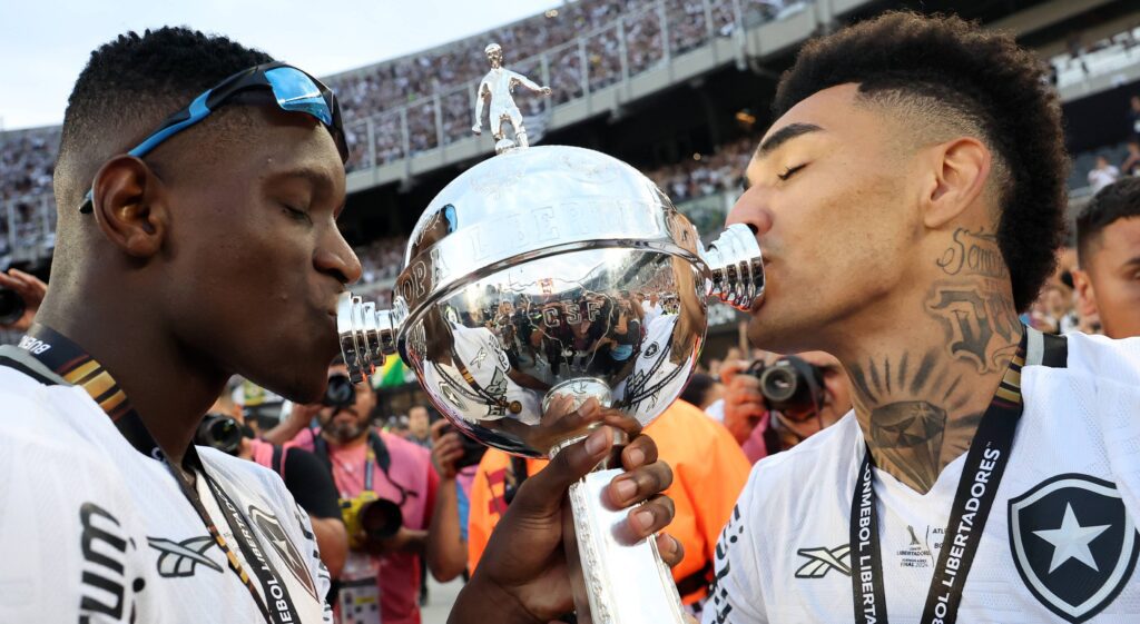 Imagem de Luiz Henrique e Igor Jesus beijando a taça da Libertadores após título do Botafogo. Foto: Vitor Silva/Botafogo