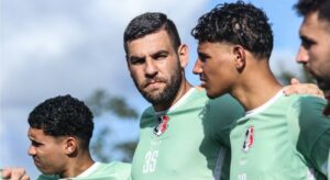 Imagem dos jogadores do Santa Cruz abraçados em roda de conversa antes do treino. Foto: Evelyn Vitória/SCFC